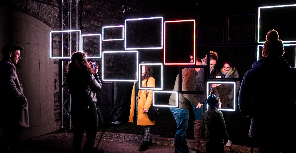 People looking at an installation of light art